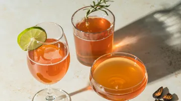 Three cocktails with garnishes on table.