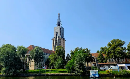 Tall tower with antenna, surrounded by trees.