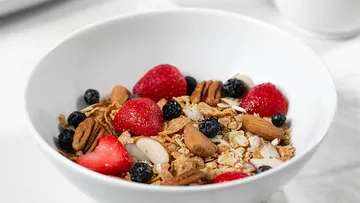 Müsli mit Beeren und Nüssen in einer Schale.