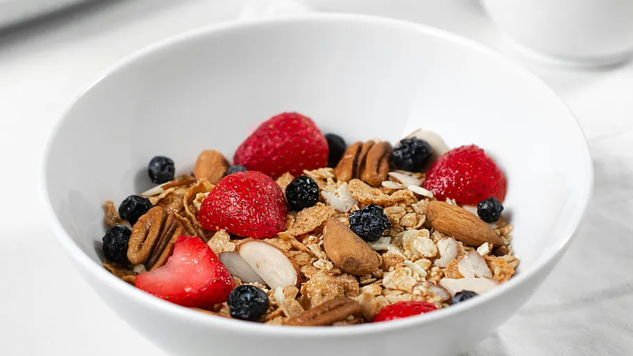 Müsli mit Beeren und Nüssen in einer Schale.