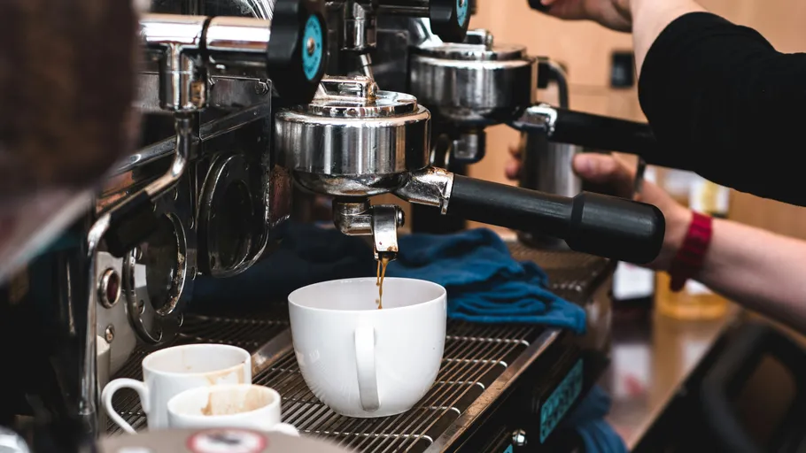 Espressomaschine brüht Kaffee in Tasse.