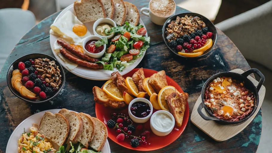 Various breakfast dishes on a wooden table.