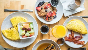 Breakfast on table with pancakes and omelette.
