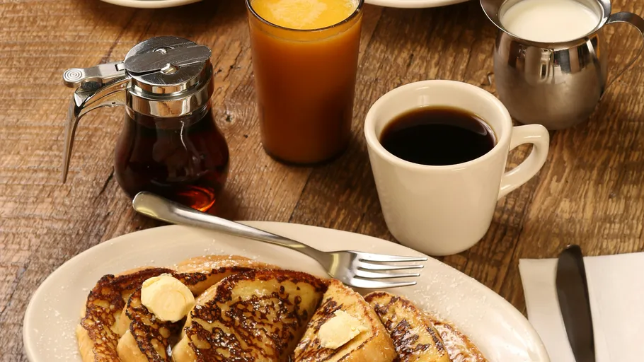 French Toast mit Butter, Kaffee, Saft, Sirup.