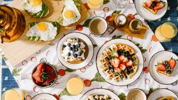 Breakfast table with waffles and avocado toast.
