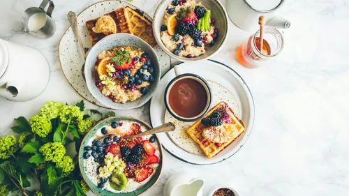 Various breakfast dishes with fruits on table.