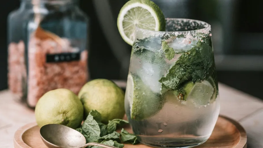 Mojito cocktail with lime and mint on table.