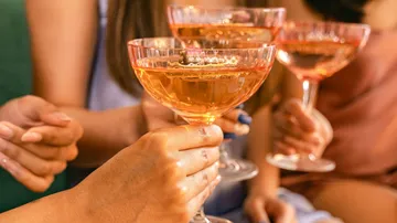 People holding champagne glasses toasting together.