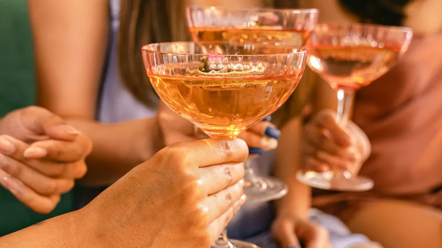 Personen halten Champagnergläser beim Anstoßen.