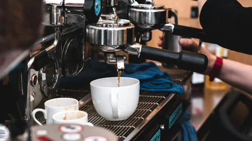 Barista making espresso in a coffee shop.