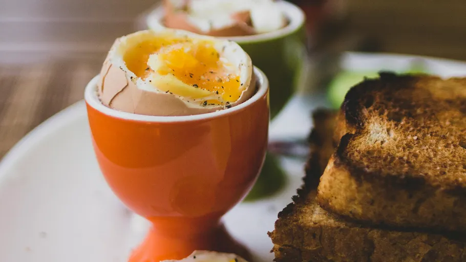 Soft-boiled egg in egg cup with toast.