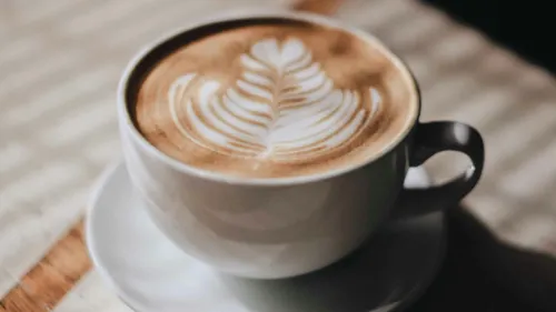 Latte art in cup on table.