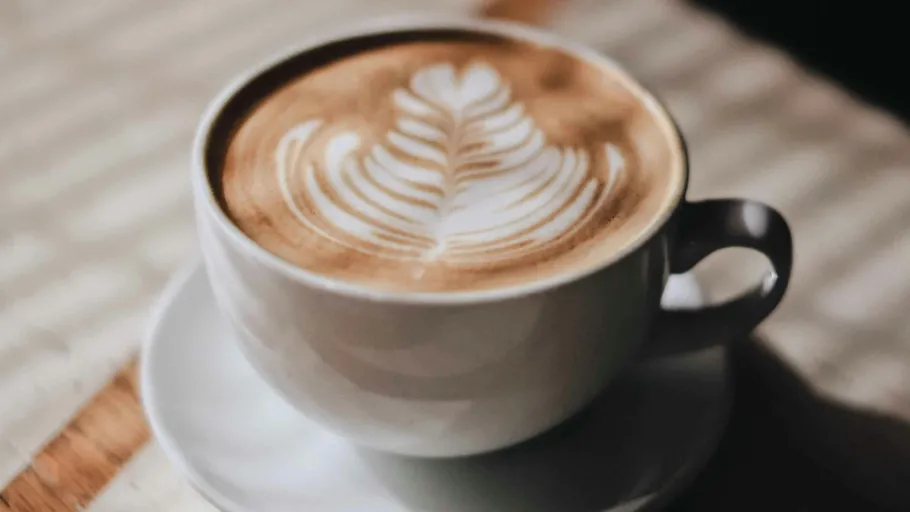 Latte Art in Tasse auf Tisch.