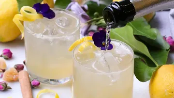 Cocktails with lemon garnish being poured.