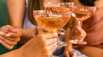 Hands holding glasses of champagne, in celebration.