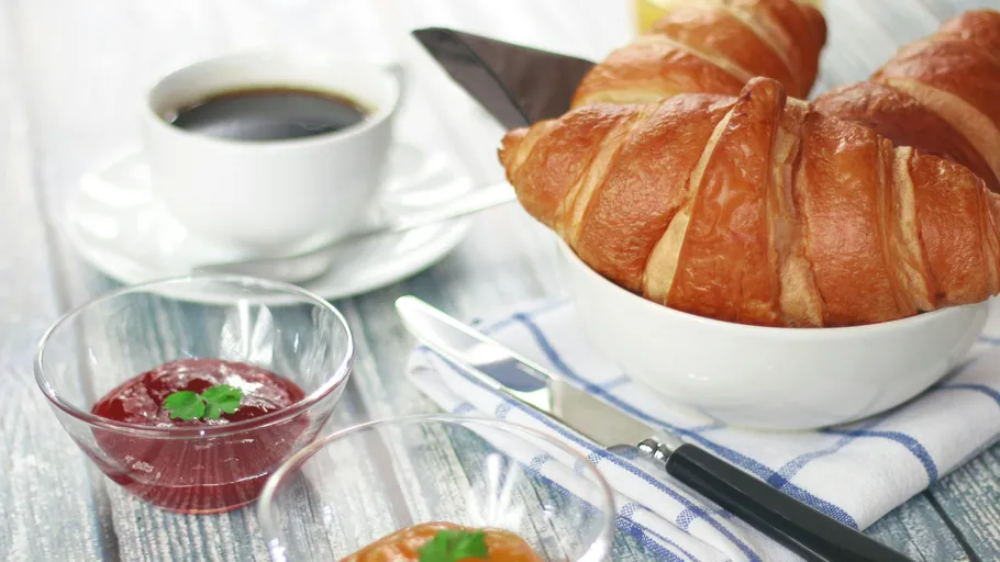 Croissants und Kaffee auf einem Frühstückstisch.