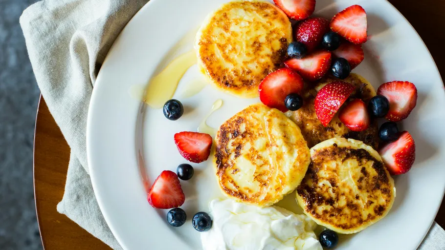 Cheese pancakes with berries on a plate.