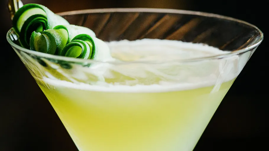 Grüner Cocktail mit Gurken-Garnitur.