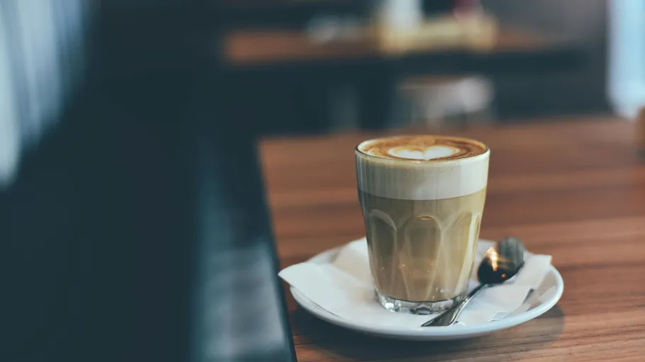 Latte im Glas auf einem Café-Tisch.