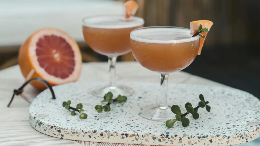 Cocktails mit Grapefruit-Garnitur auf Tablett.