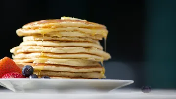 Stapel Pfannkuchen mit Sirup und Beeren.