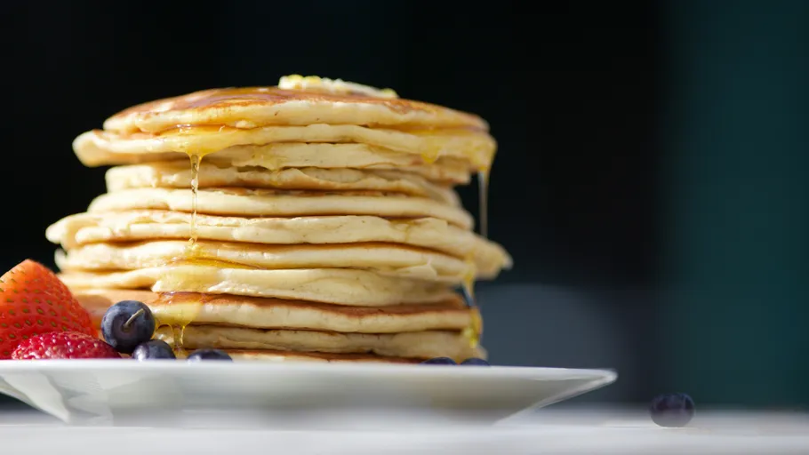 Stapel Pfannkuchen mit Sirup und Beeren.
