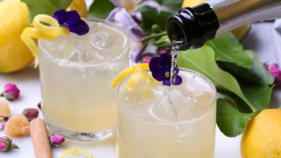Cocktails with ice and lemon, being poured.
