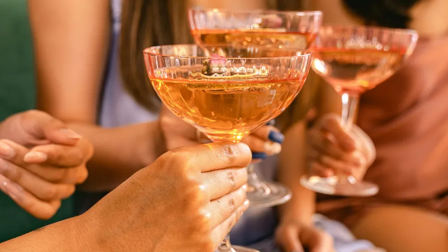 Hands holding champagne glasses in celebration.