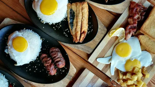 Breakfast plates with eggs, rice, meat, and toast.