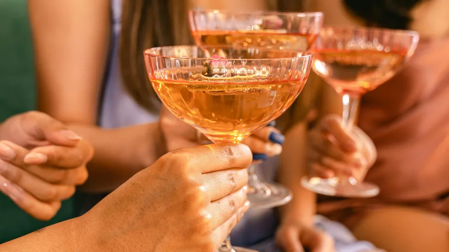 Hände halten Champagnergläser zum Feiern.