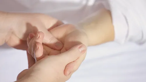 Hände geben eine sanfte Massage im Bett.