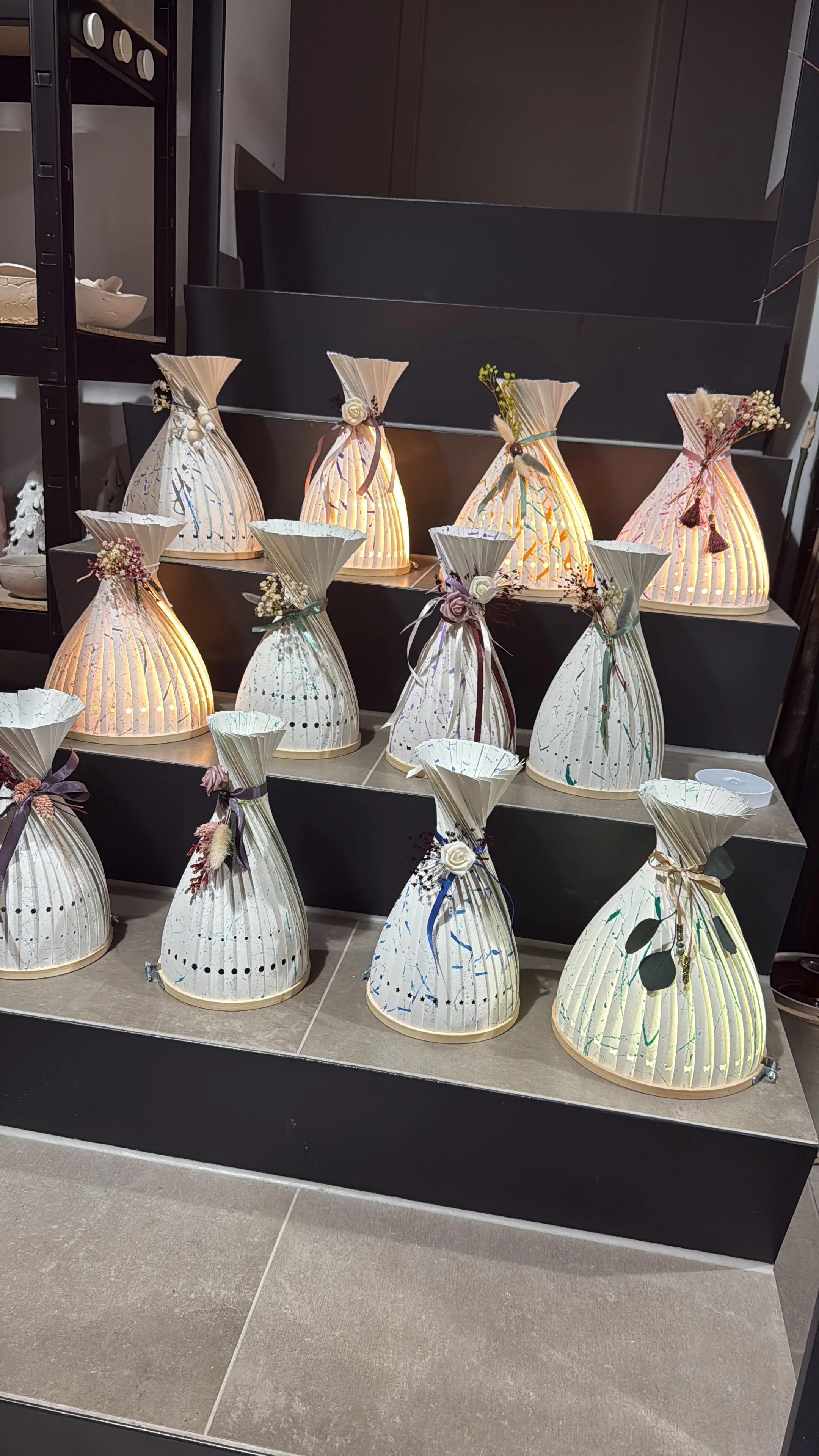 Dekorative beleuchtete Vasen auf Ausstellungsregalen.