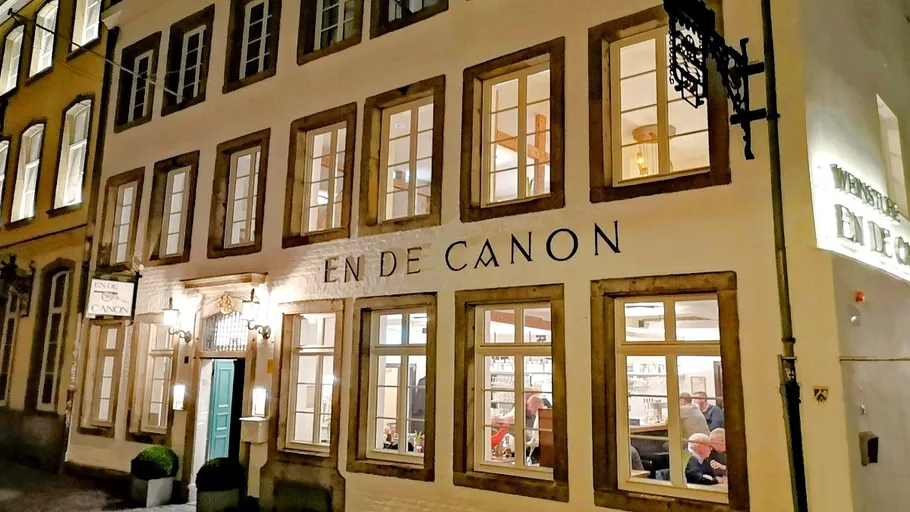 Gebäudefassade mit beleuchteten Fenstern bei Nacht.