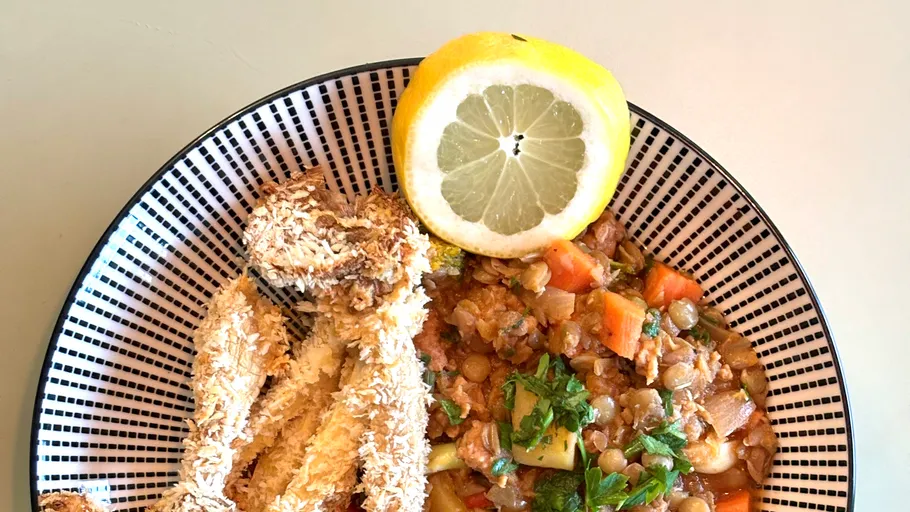 Panierter Fisch mit Zitrone und Gemüseeintopf.