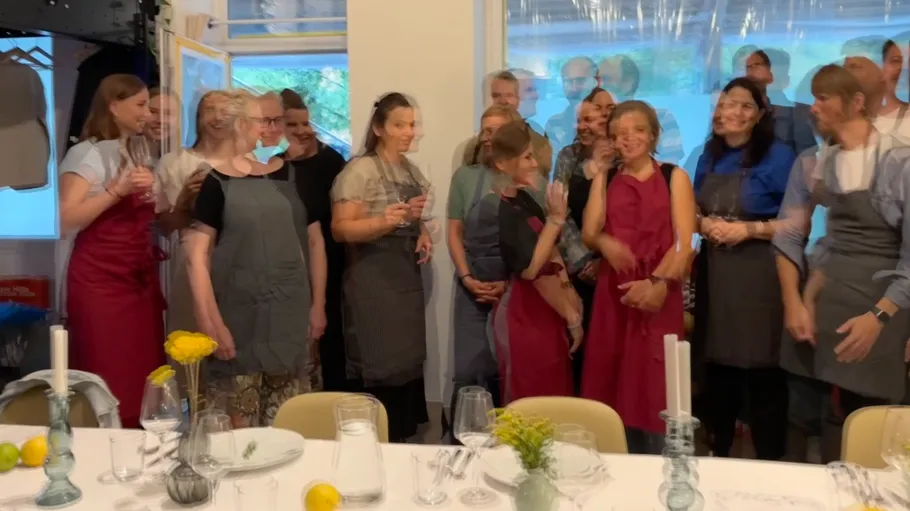 Gruppe von Personen in Schürzen feiern drinnen.