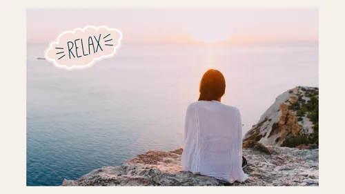 Person sitting on cliff watching sunset.