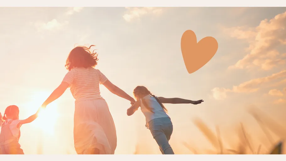 Family holding hands running in field.