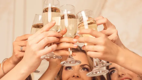 Hands raising champagne glasses in celebration.