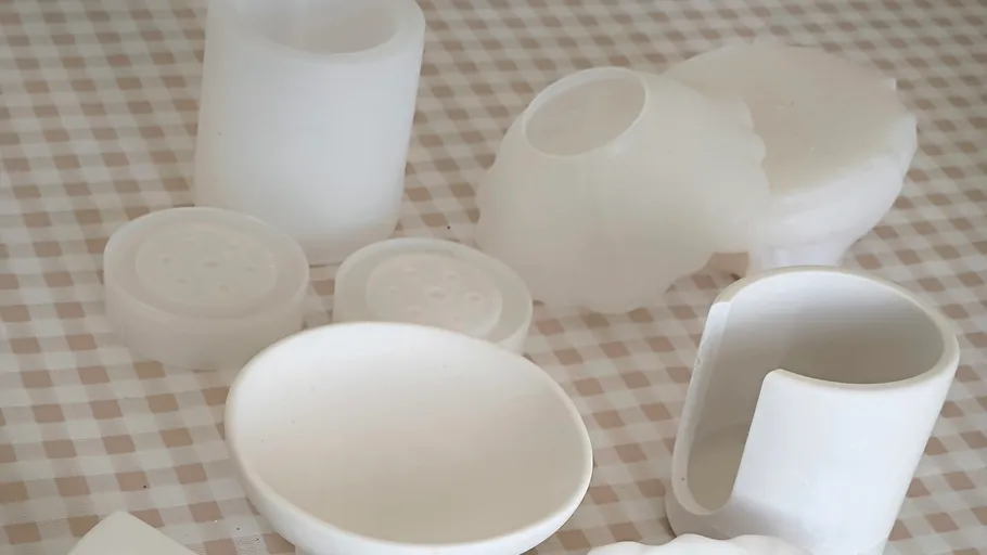 Weiße Plastikgegenstände auf kariertem Tischtuch.