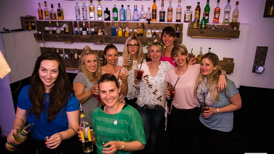 Gruppe von Frauen mit Getränken in einer Bar.