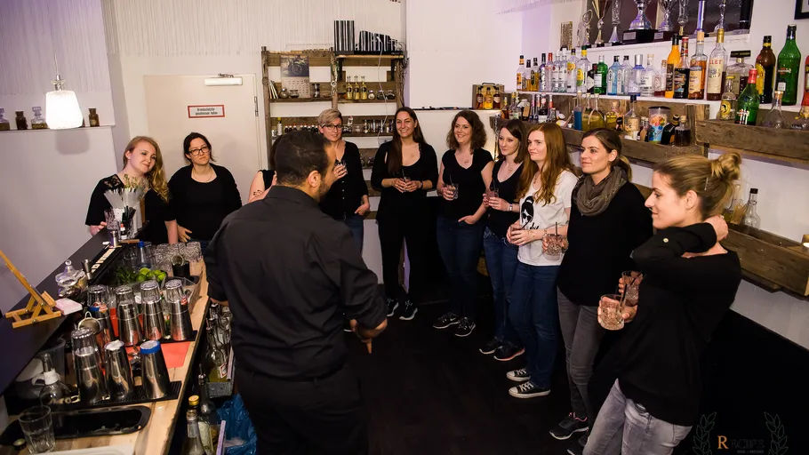 Barkeeper zeigt Gruppe etwas in einer Bar.