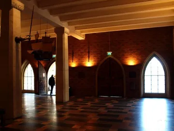 Raum mit gemustertem Boden, beleuchtet von Fenstern.