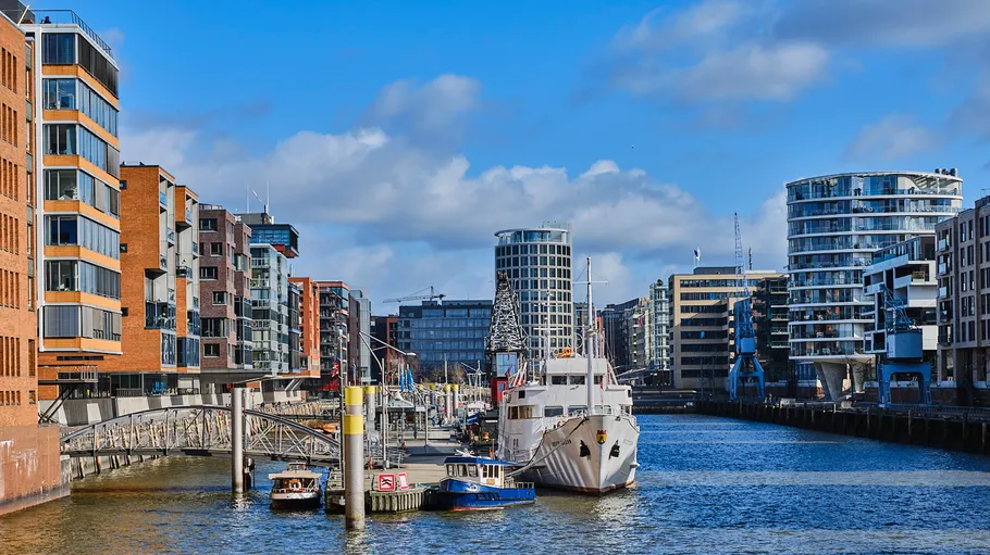 Boats docked in urban waterway with buildings.