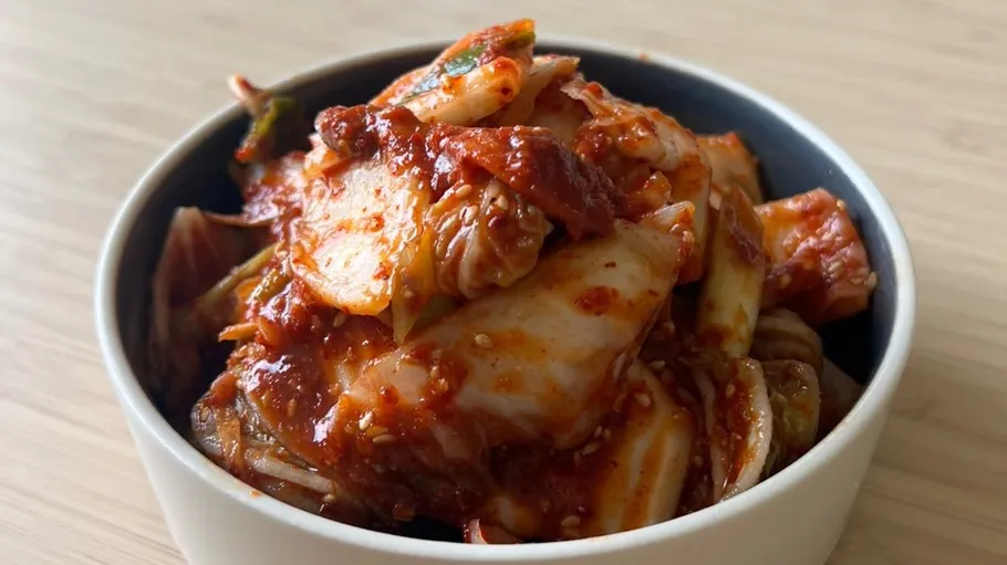 Kimchi in a bowl on wooden table.