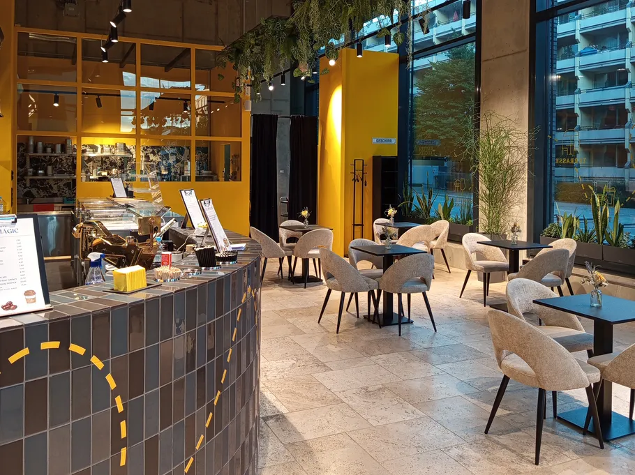 Modern cafe with tables and chairs, bright interior.