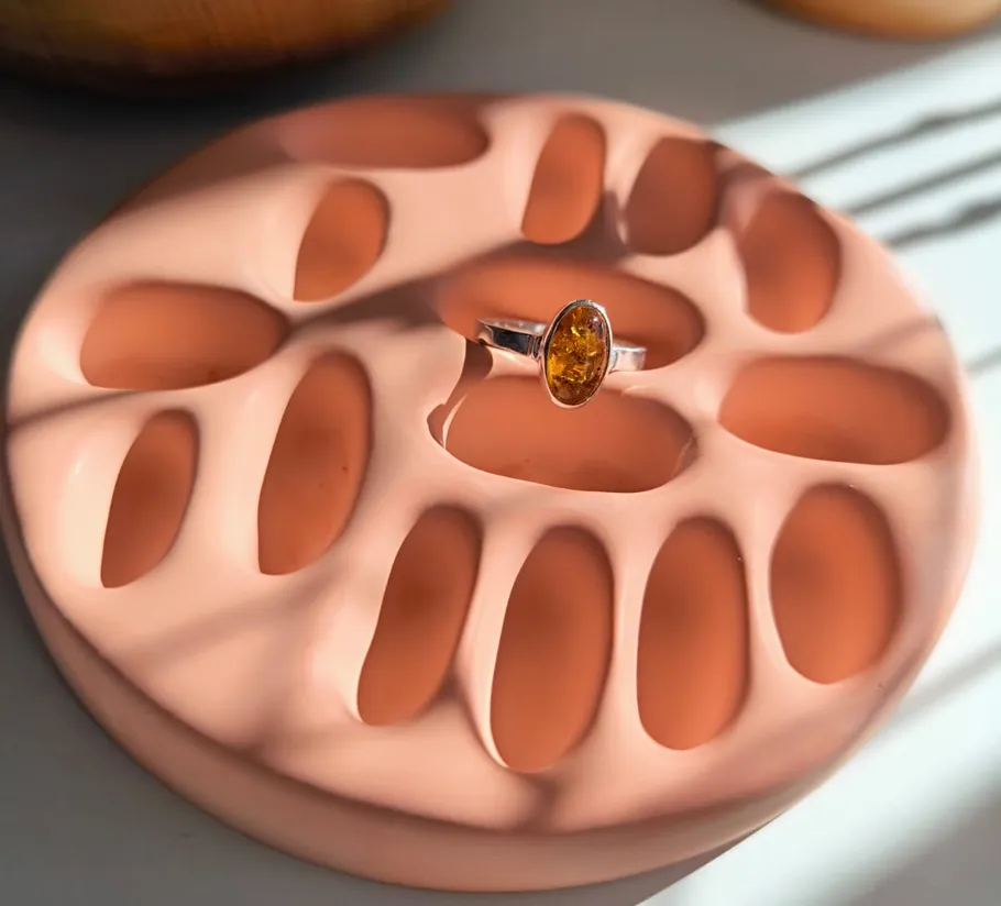 Gemstone ring on textured surface with sunlight.