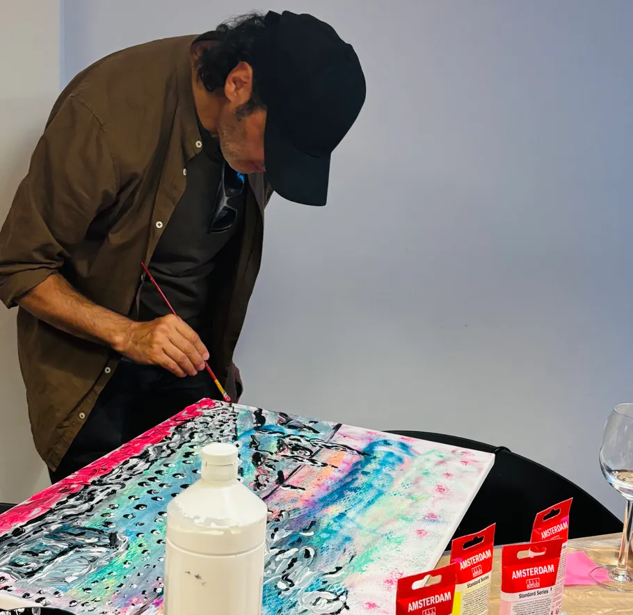 Man painting abstract artwork in a studio.