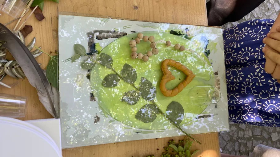 Blattkunst auf Tisch mit Händen in der Nähe.