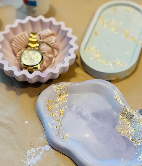 Decorative trays with gold leaf accents on table.