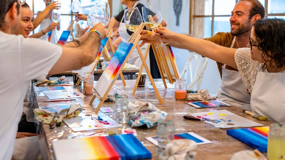 Personen malen und stoßen in Kunststudio an.